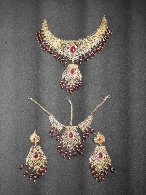 Bridal jewelry set featuring a gorgeous necklace, maang tikka, and earrings, combining traditional charm with timeless elegance.