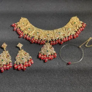 Elegant gold-tone women's jewelry set, including a captivating step necklace, Maang Tika, Earrings and Nose Ring adorned with vibrant red beads for a touch of sophistication and style