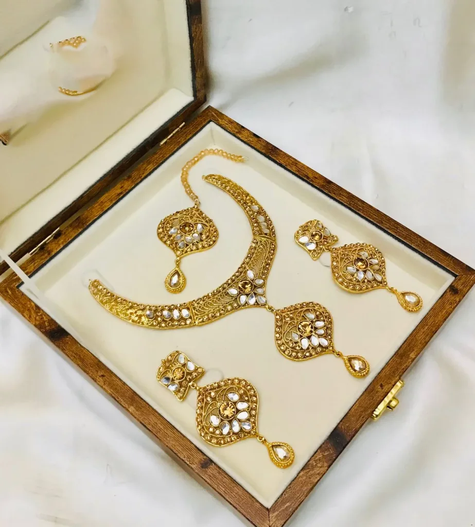 A perfect choice for women's jewellery fashion, This Gold-Plated Necklace set is crafted in traditional antique style, Necklace set features a long tassel along with Jhumka and maang tikka for a stunning and unique look 