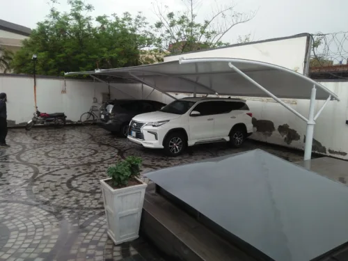 Modern car parking shed design in Pakistan, showcasing innovative architecture with a top membrane crafted from durable tensile fabric. The structure provides Sun and Rain protection for vehicles.