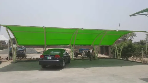 A beautiful modern car parking shade that covers the vehicle from direct sunlight and rain. The top membrane of PVC tensile fabric provides more strength to the base ms structure