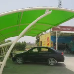 A beautiful modern car parking shade that covers the vehicle from direct sunlight and rain. The top membrane of PVC tensile fabric provides more strength to the base ms structure