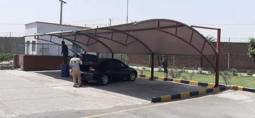 an innovative car parking shade design at the best price in Pakistan is now available. This modern car parking shed features a tensile fabric membrane for perfect vehicle protection from sun and rain. Tensile fabric structures are more reliable and long-lasting. This car parking shed was installed at Sadaqat Textile, Faisalabad